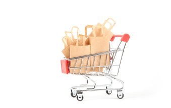 Shopping cart with purchases - packages on white background isolated. Sale concept. Use of eco-friendly materials. Zero waste